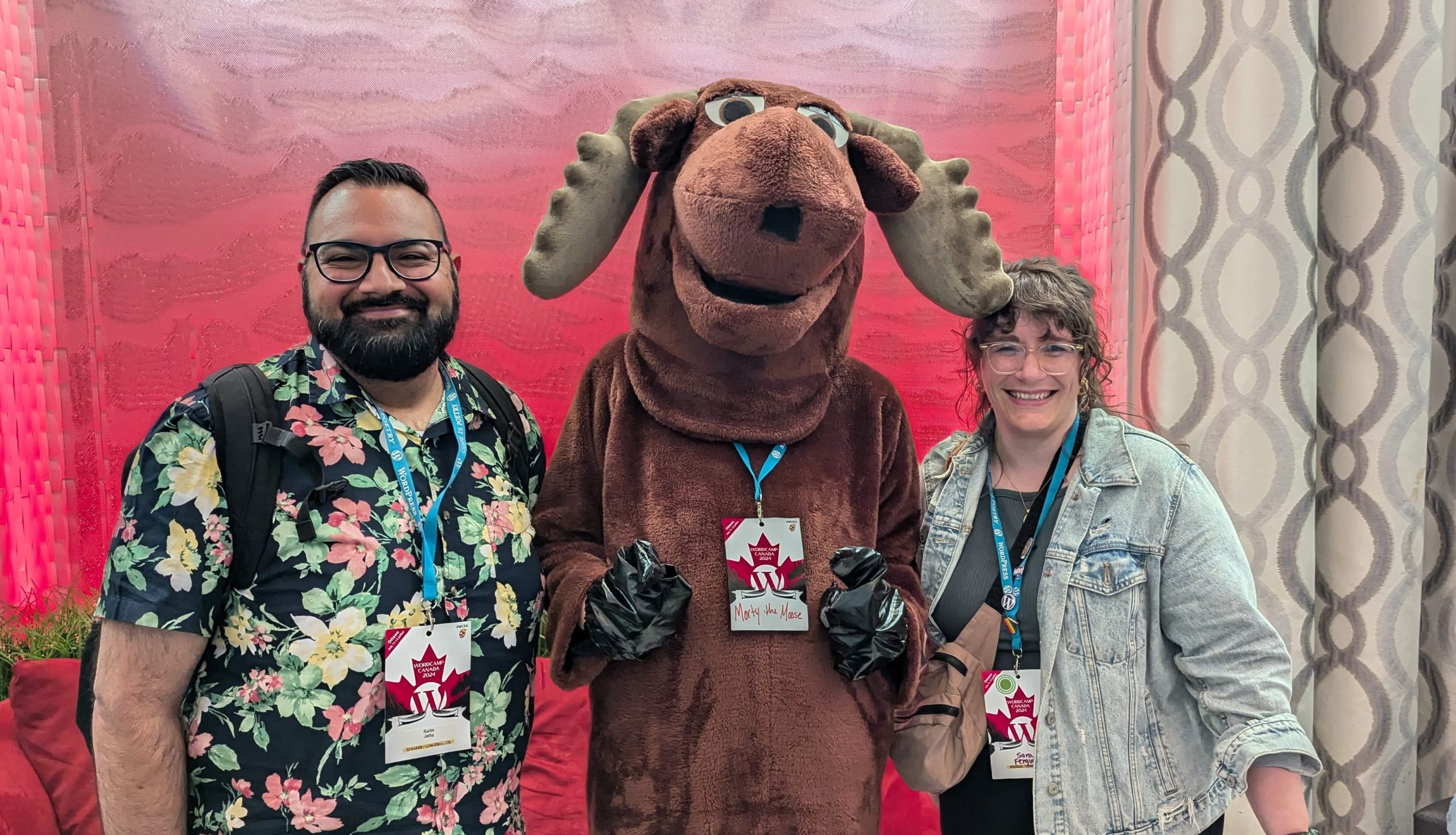 A picture of Sara and Karim standing with a moose mascot.